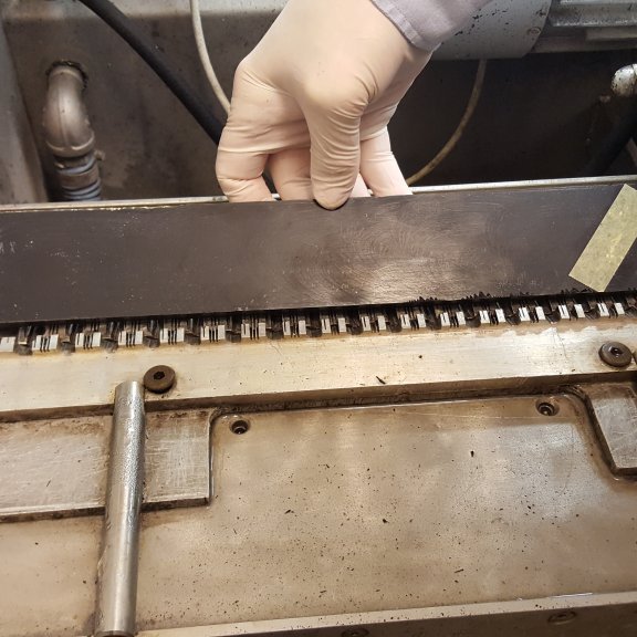 Búið er að losa resínkubb úr bakka og hann settur í sögina.