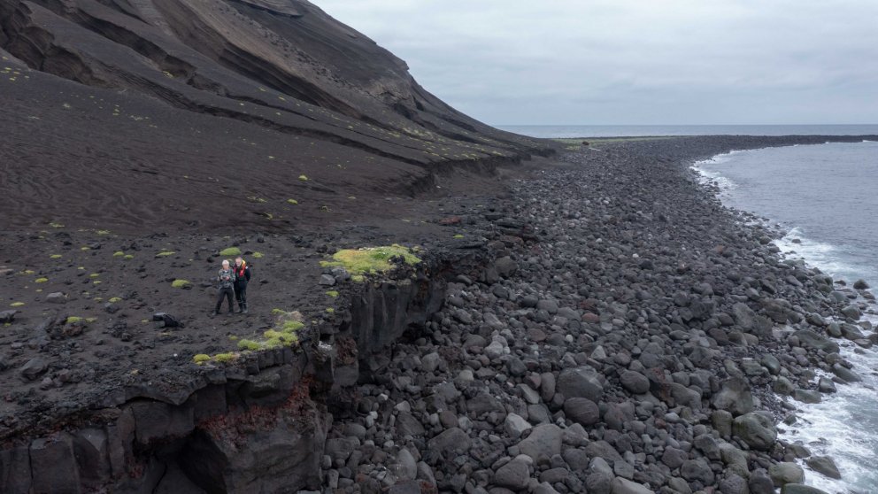Sandur og grjót hefur safnast í tanga sem gengur norður úr Surtsey. Þörungar eiga erfitt með að ná f…