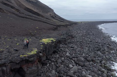 Sandur og grjót hefur safnast í tanga sem gengur norður úr Surtsey. Þörungar eiga erfitt með að ná f…