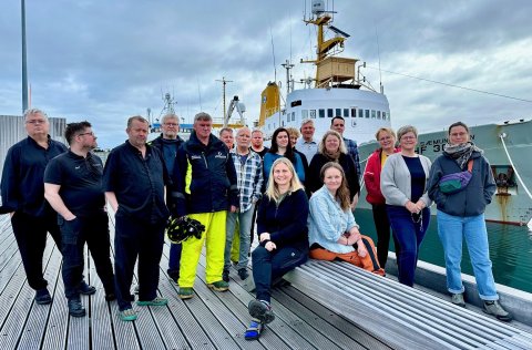 Kampakátur hópur rannsóknafólks og áhafnameðlima sem brosti framan í myndavélina áður en rannsóknask…